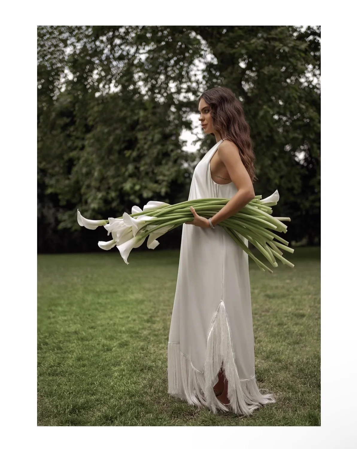 White dress fashion editorial with calla lilies in a garden, photographed by Mariya Harley