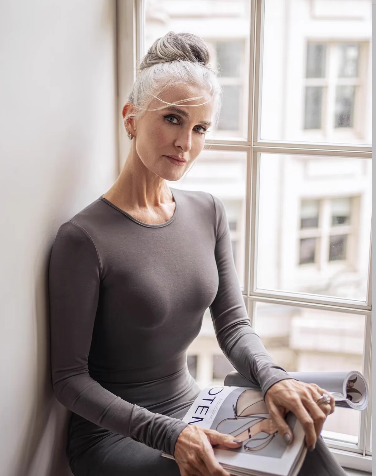Silver-haired fashion portrait by a London window, photographed by Mariya Harley